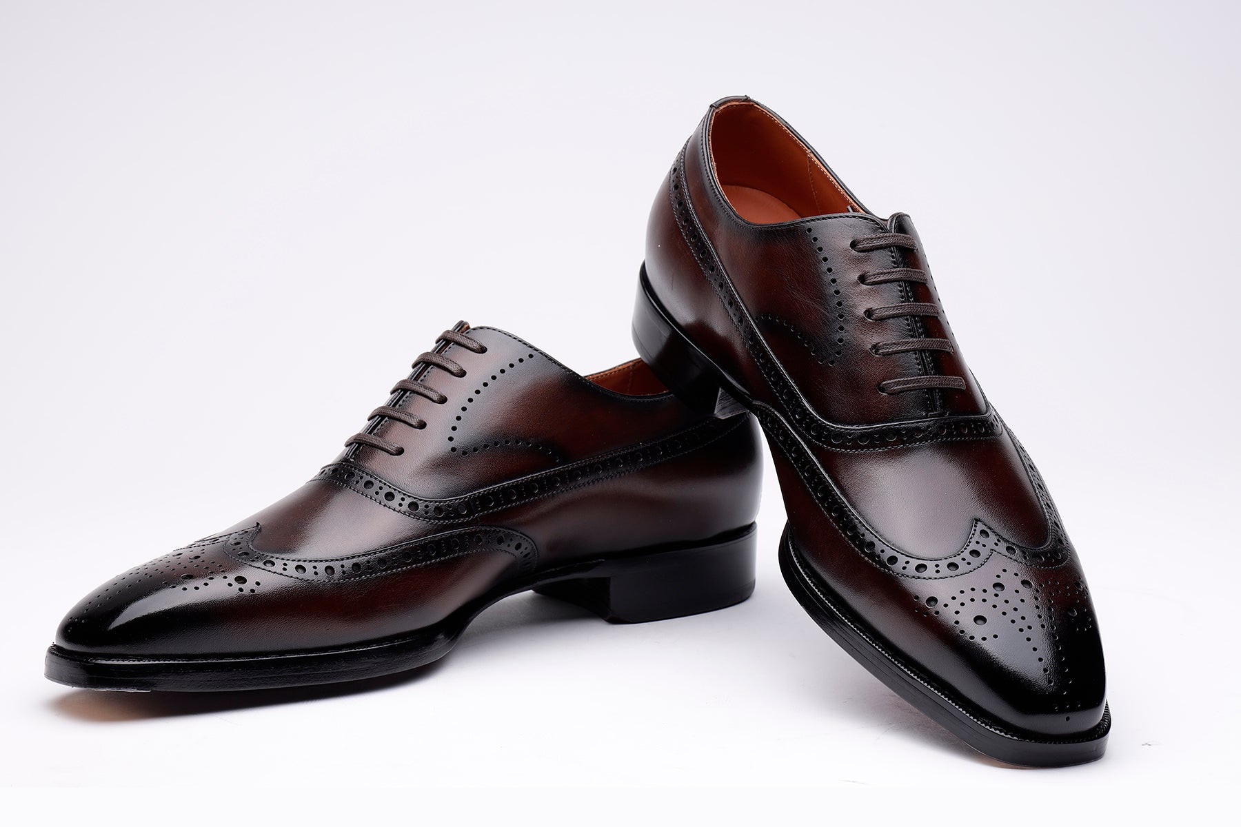 Pair of brown leather dress shoes on a white background